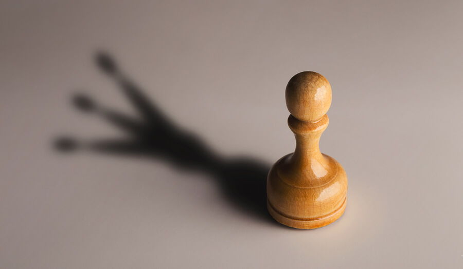 pawn chess piece with shadow of queen
